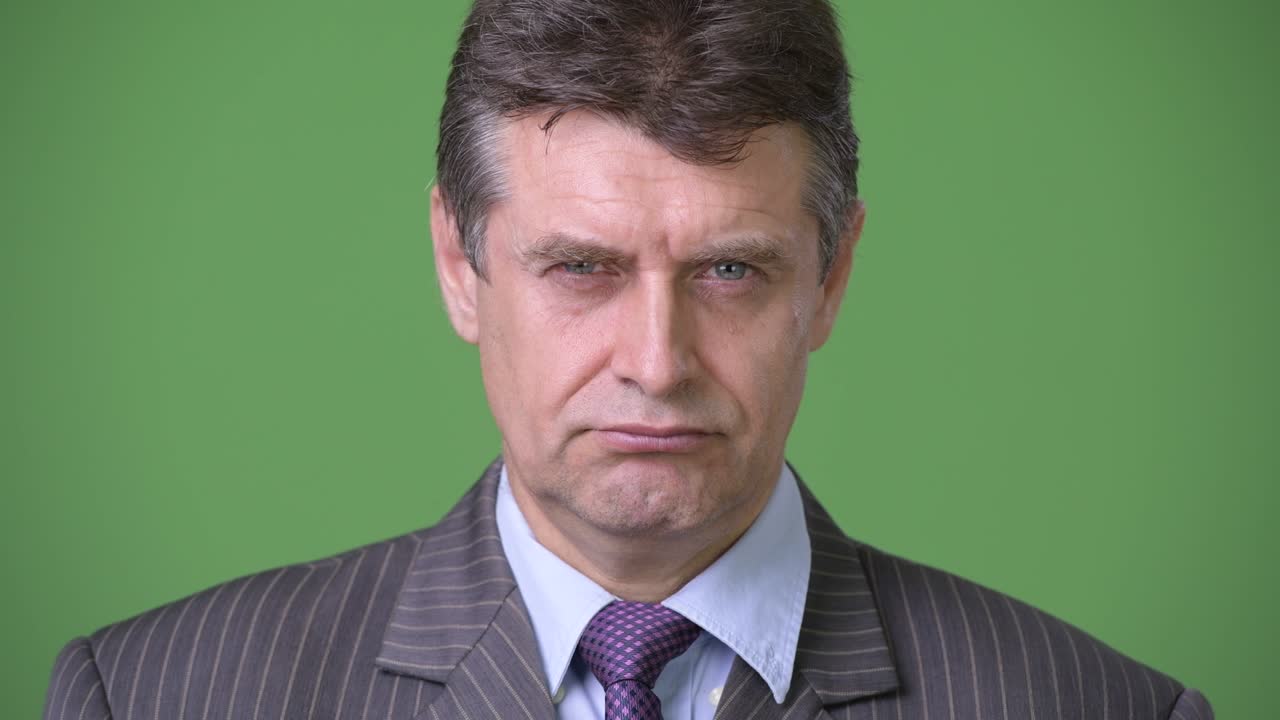 Moden kjekk forretningsmann mot grønn bakgrunn