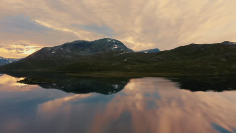 Hermosos-Reflejos-De-La-Montaña-Y-El-Cielo-En-El-Lago-Vavatnet-Durante-La-Puesta-De-Sol-En-El-Valle-Hydalen,-Hemsedal,-Noruega