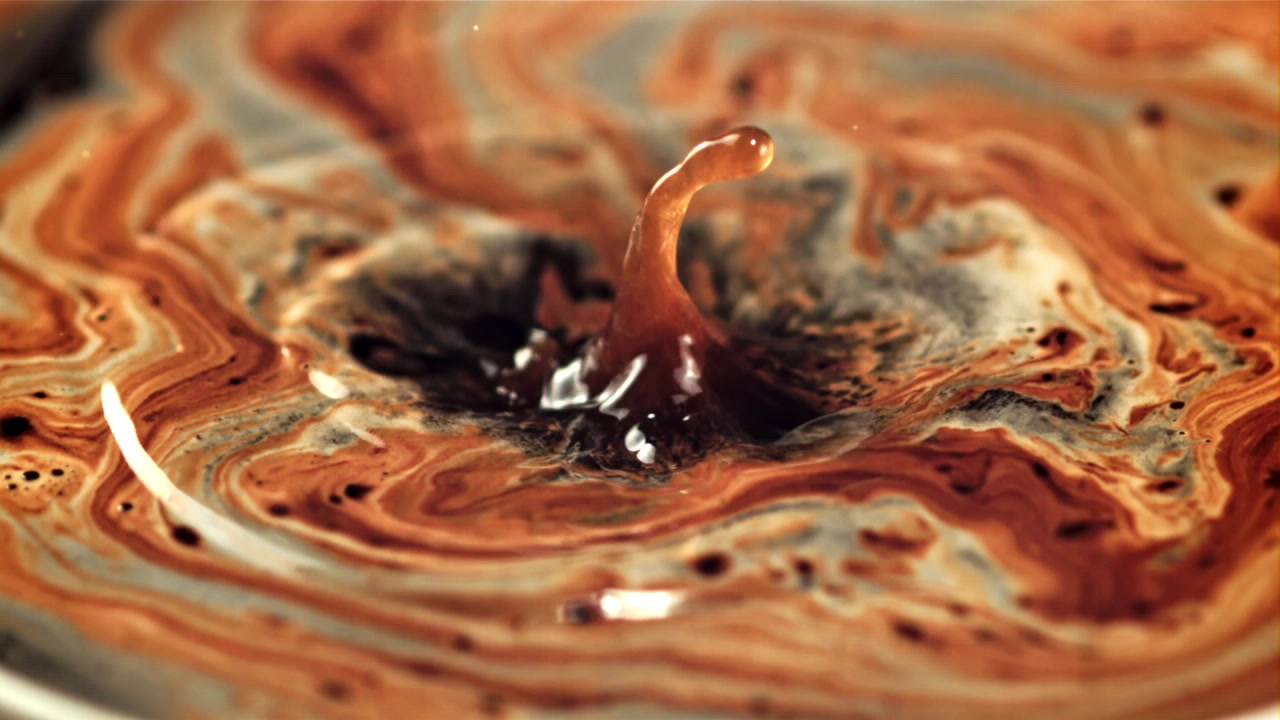 Slow Motion Liquid Drop Splashing into Swirling Coffee Patterns