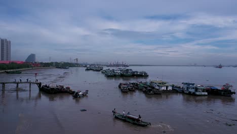 Aerial-view-of-maritime-workers-boarding-small-boats-at-Saigon-River-jetty,-Vietnam