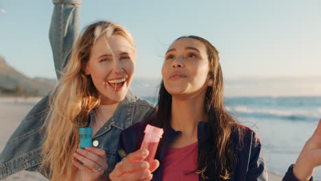 teenage girls blowing bubbles on beach at sunset best friends having fun summer playing by the sea enjoying friendship