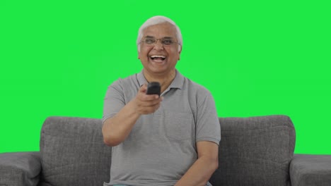 Happy-Indian-old-man-watching-TV-and-laughing-Green-screen