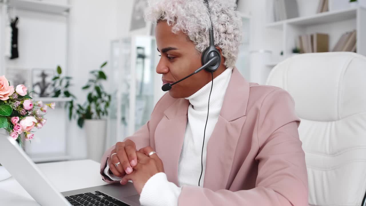 Young hispanic business woman wearing headset communicating by video call