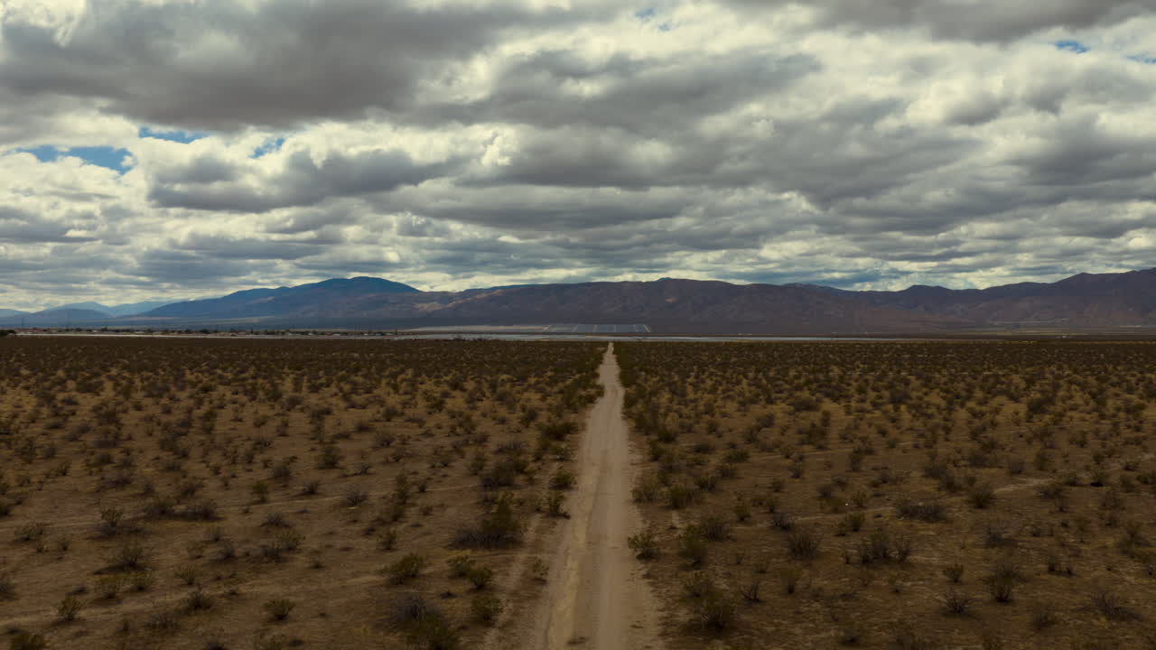 paisaje nuboso aéreo hiper lapso sobre el desierto de mojave con líneas principales desde un camino de tierra