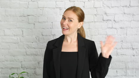 a business woman waving hello to the camera on a video call conference