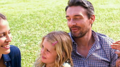 cute family sitting in the grass