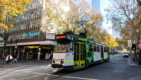 un tranvía se mueve a través de una concurrida calle de melbourne