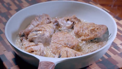 taking fried chicken in a skillet off the heat and allowing to rest