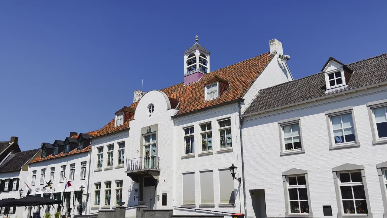 Establishment shot of the Kloosterberg in Wijngaart, Thorn with a view of the pure white building in Dutch architecture on a sunny cloudless day