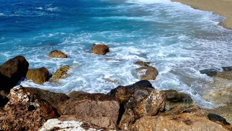 static and peaceful shot of waves crashing on an empty beach in the coastal town of varigotti in the italian riviera