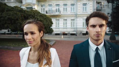 Smiling-lady-and-business-man-walking-in-city-center