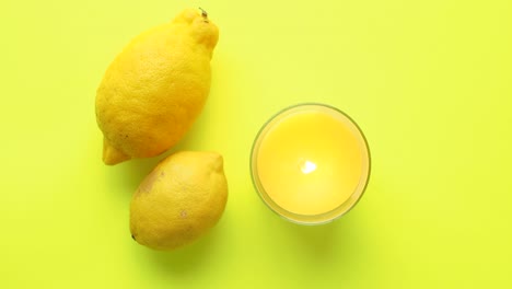 limones y velas sobre un fondo amarillo