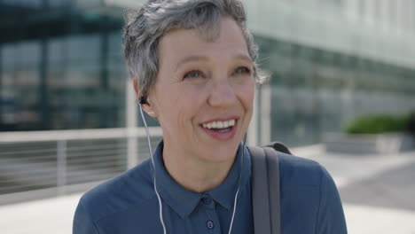 Retrato-De-Una-Mujer-De-Negocios-Profesional-De-Alto-Nivel-Sonriendo-Feliz-Usando-Auriculares-Disfrutando-Escuchando-Música-En-El-Fondo-Urbano-De-La-Ciudad