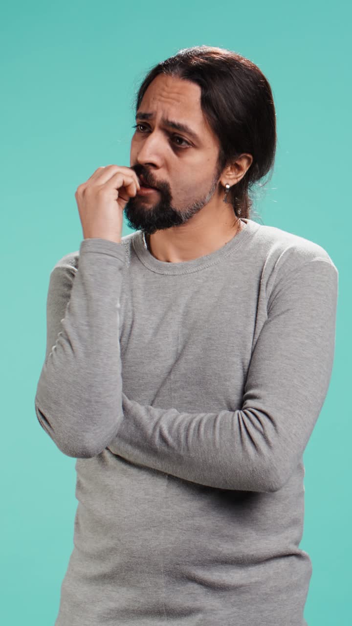 Vertical video Distraught man biting nails, being afraid of receiving troubling bad news