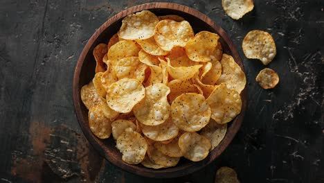 bowl of crispy potato chips on rustic background