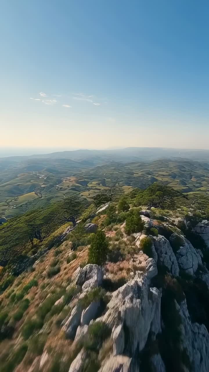 Video verticale: drone in volo, pilota che inizia la discesa in avanti, ispezionando la cresta calcarea e il mare