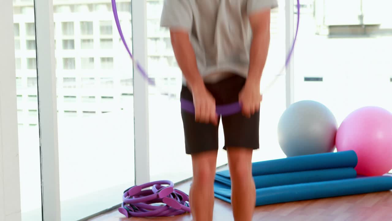 ⁇ 한 남자가  ⁇ 라 후프를 뛰어넘고 있다