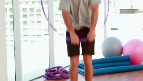 hombre en forma saltando a través de un hula hoop