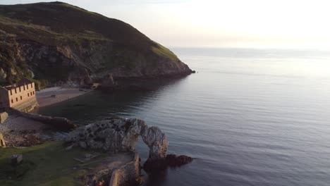 porth wen abandoned coastal derelict brickworks remains golden sunrise countryside bay aerial view pan left across port