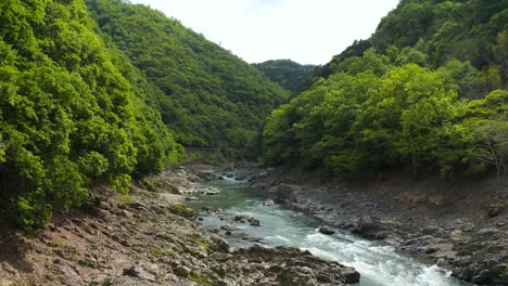 Hozukyo-Bridge-and-Katsura-River,-Aerial-Pullback-in-Arashiyama,-Kyoto-Japan