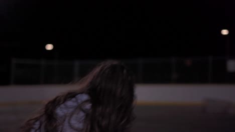 Following-a-teenage-girl-with-long-brown-hair-dribbling-then-shooting-basketball-at-outdoor-court-at-night