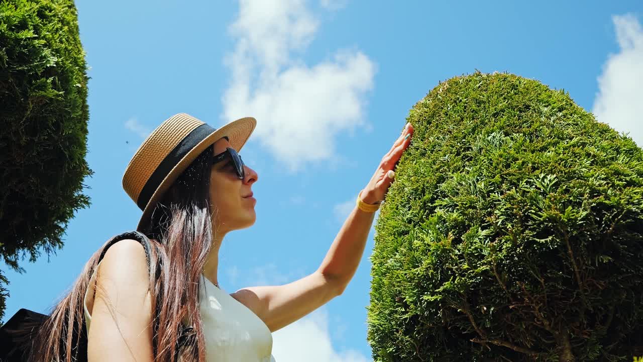 Baroque topiary meets human presence in calm garden moment of reflection