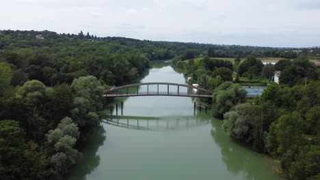 aerial drone shoot over a river bridge at chalifert, france