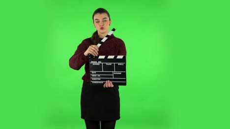 mujer con clapperboard en la pantalla verde