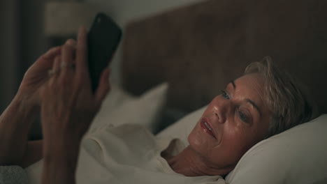 phone, night and a senior woman in bed