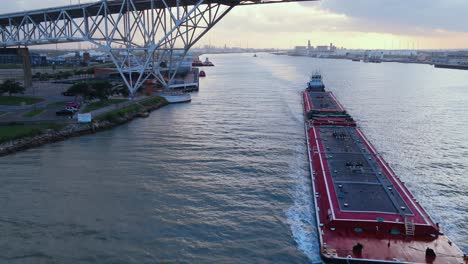 barcaza de trabajo saliendo del puerto bajo el puente de corpus christi puesta de sol en la parte de atrás