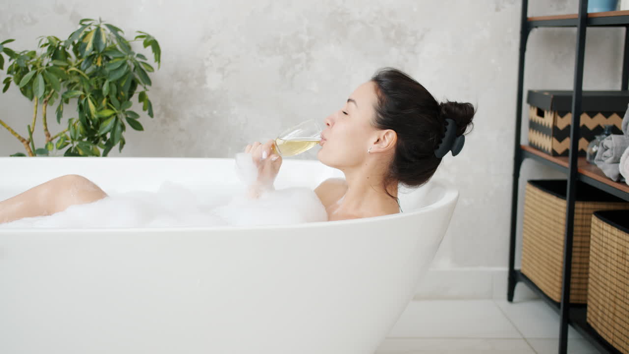 Woman enjoying a relaxing bubble bath with champagne