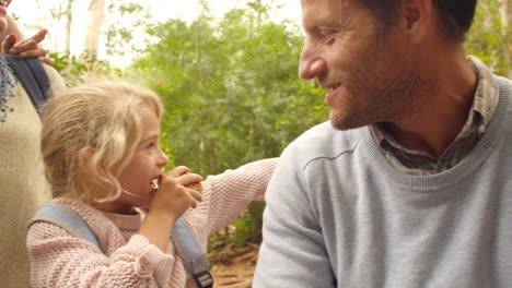 Multi-generation-family-eating-outdoors-during-a-hiking-trip