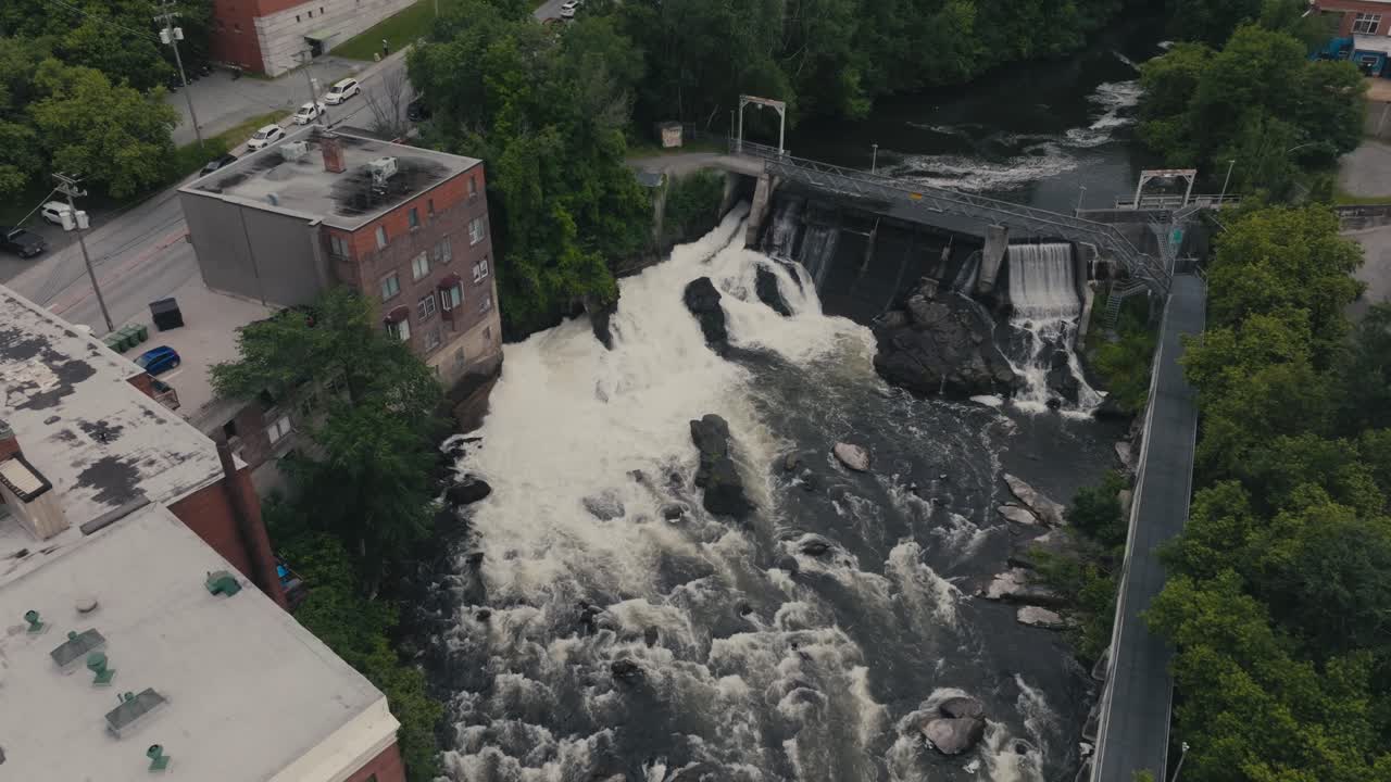 Aerial View of a River, Dam, and Waterfall in an Urban Setting