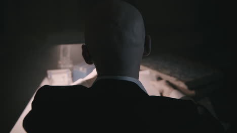 pale bald accountant looks through the tax papers in the weird room at night