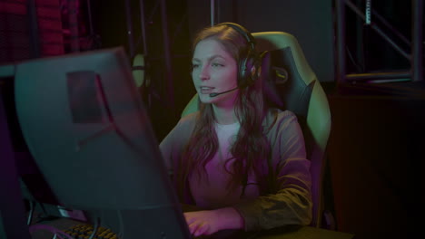 concentrated cybersport female gamer playing online video game and celebrating success