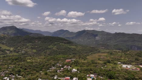 Vista-Aérea-De-Un-Pequeño-Pueblo-Con-Bosques-Y-Montañas