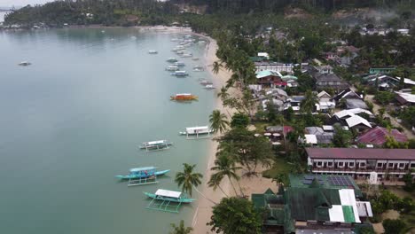 Colorful-traditional-filipino-Boats-anchored-at-calm-itaytay-Bay-in-Port-Barton-at-early-morning-after-sunrise,-Palawan---Philippines