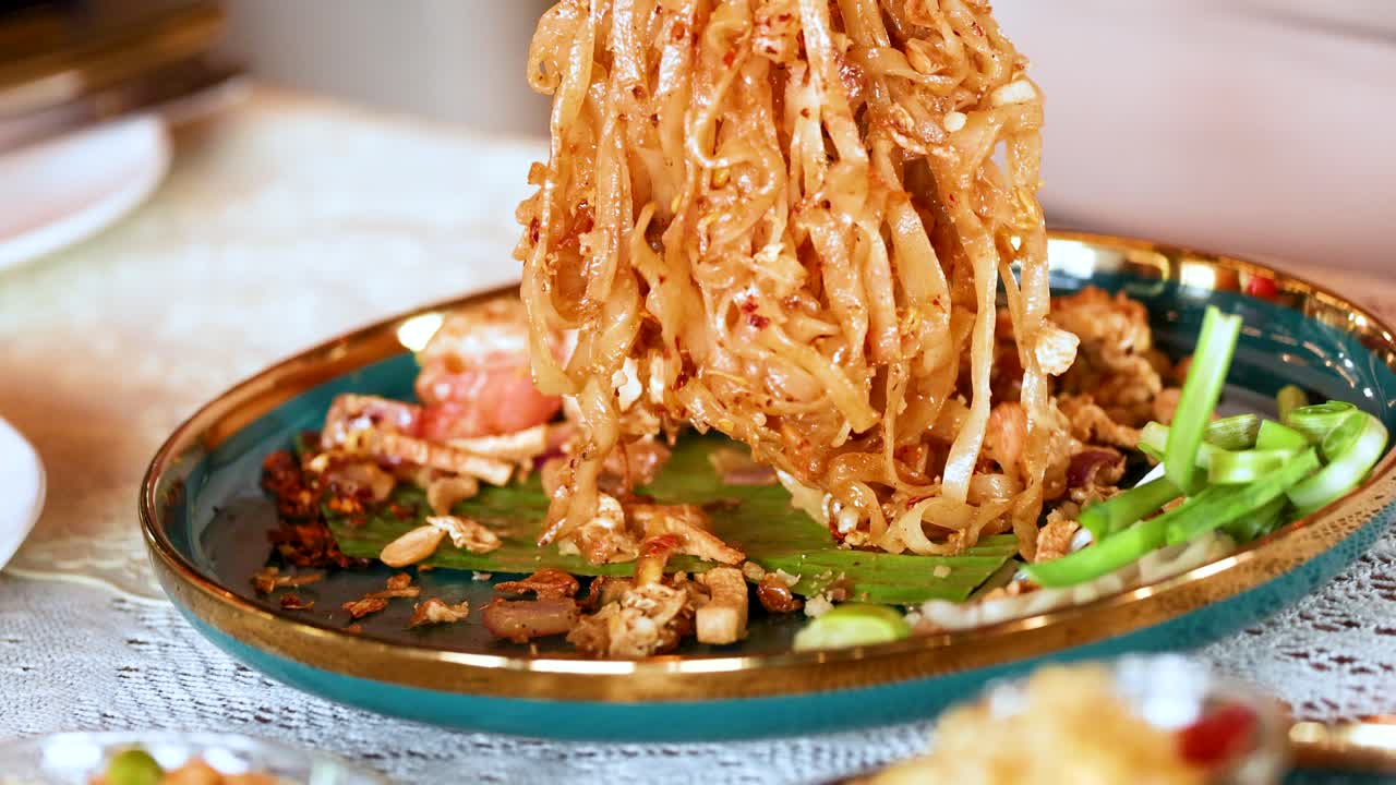 맛있는 새우 패드 타이가 제공되고 즐기고 있습니다.