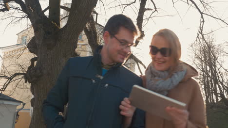 una pareja con una tableta caminando en tallin.