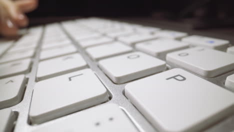 woman presses keys on computer keyboard at table in office