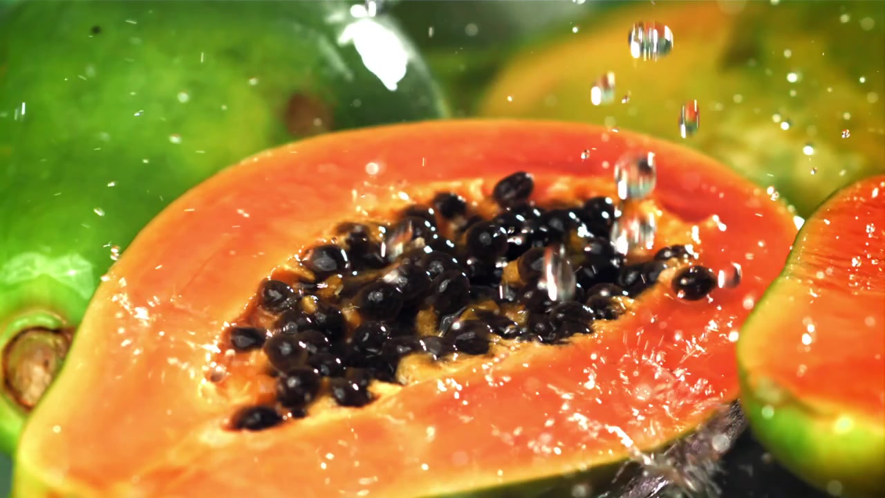 Metà di papaya fresca con gocce d'acqua al rallentatore