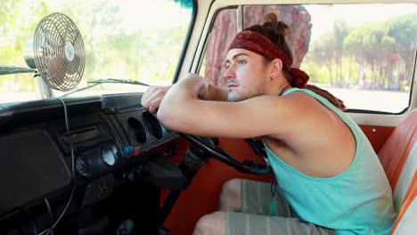 man sitting at driver seat of camper van 4k