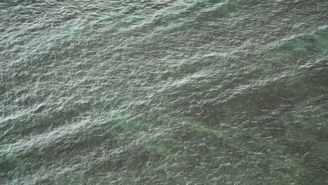 sea waves reaching the shallow waters, bright reflecting water, high angle