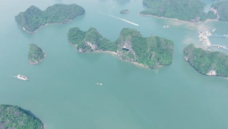 ha long bay islands with boats on calm turquoise water, vietnam, aerial view