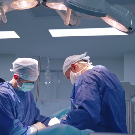 surgical process in the operating room. successful doctors in blue uniform performing an operation with medical tools on a patient in clinic.