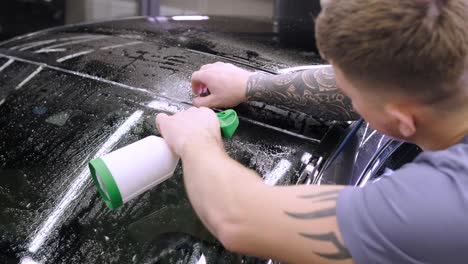 man covering car with vinyl polyurethane tape. films for the car. sticker protective film on the car