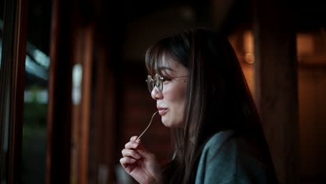woman eating dessert near the window