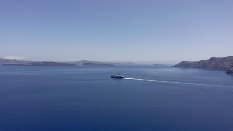 aerial: ferry boat traveling in the open blue sea between small islands