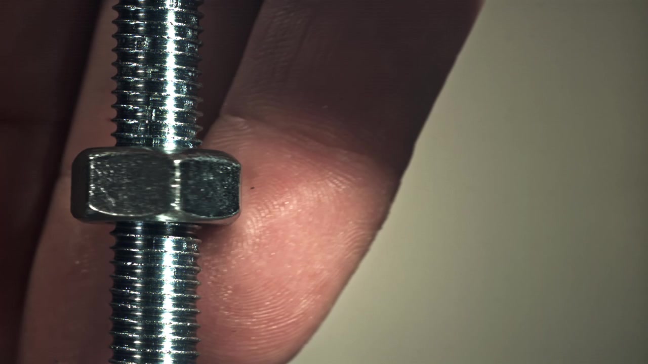 Slow Motion Close-up of a Metal Nut Tightening on a Bolt