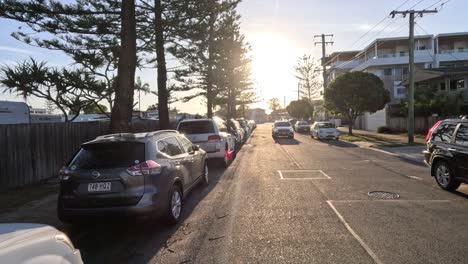 car driving down a sunlit suburban road.